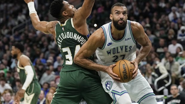 Feb 8, 2024; Milwaukee, Wisconsin, USA; Minnesota Timberwolves center Rudy Gobert (27) looks to shoot around Milwaukee Bucks forward Giannis Antetokounmpo (34) during the second quarter at Fiserv Forum.